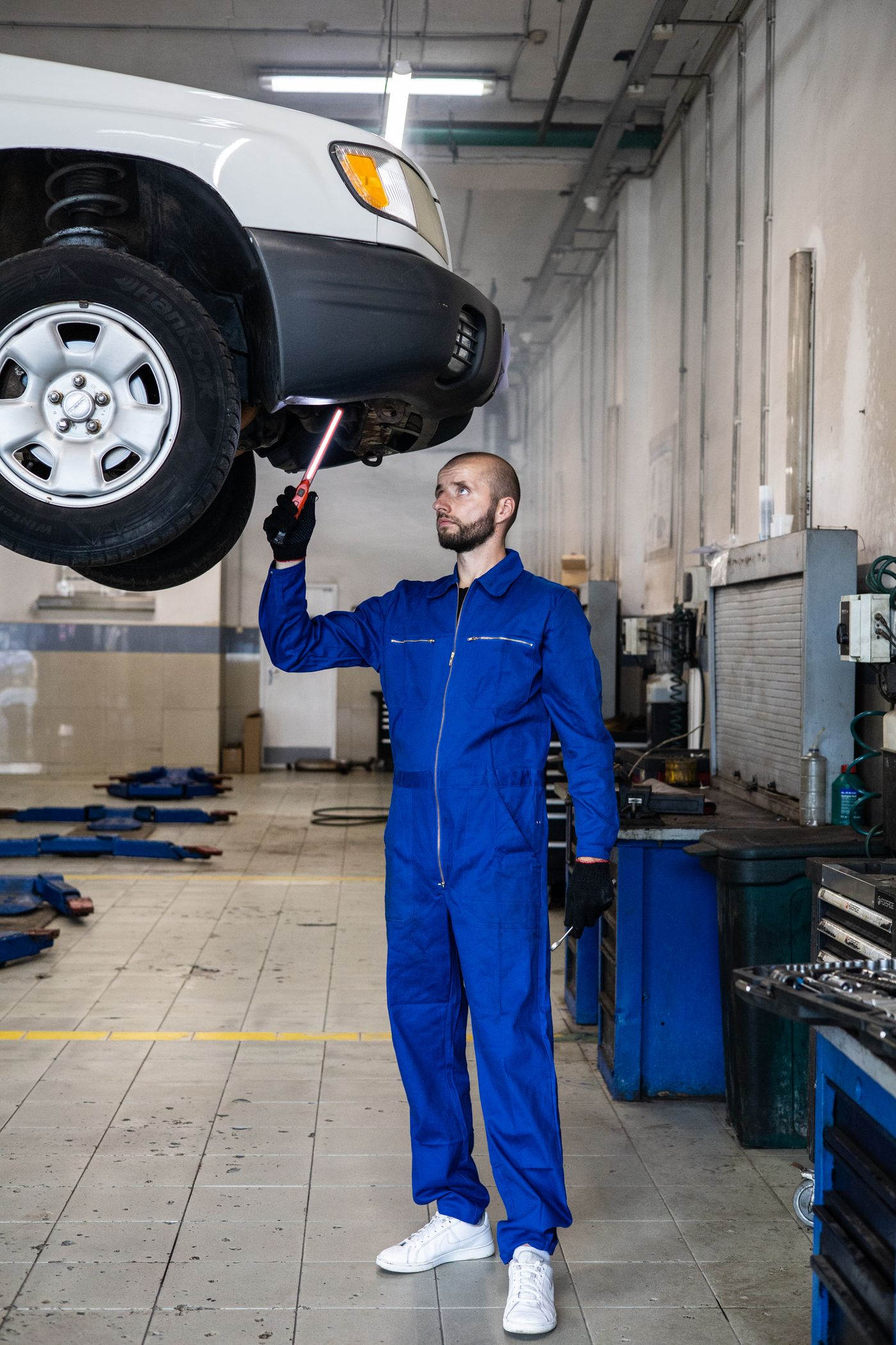 Mechanic inspecting a car on a lift