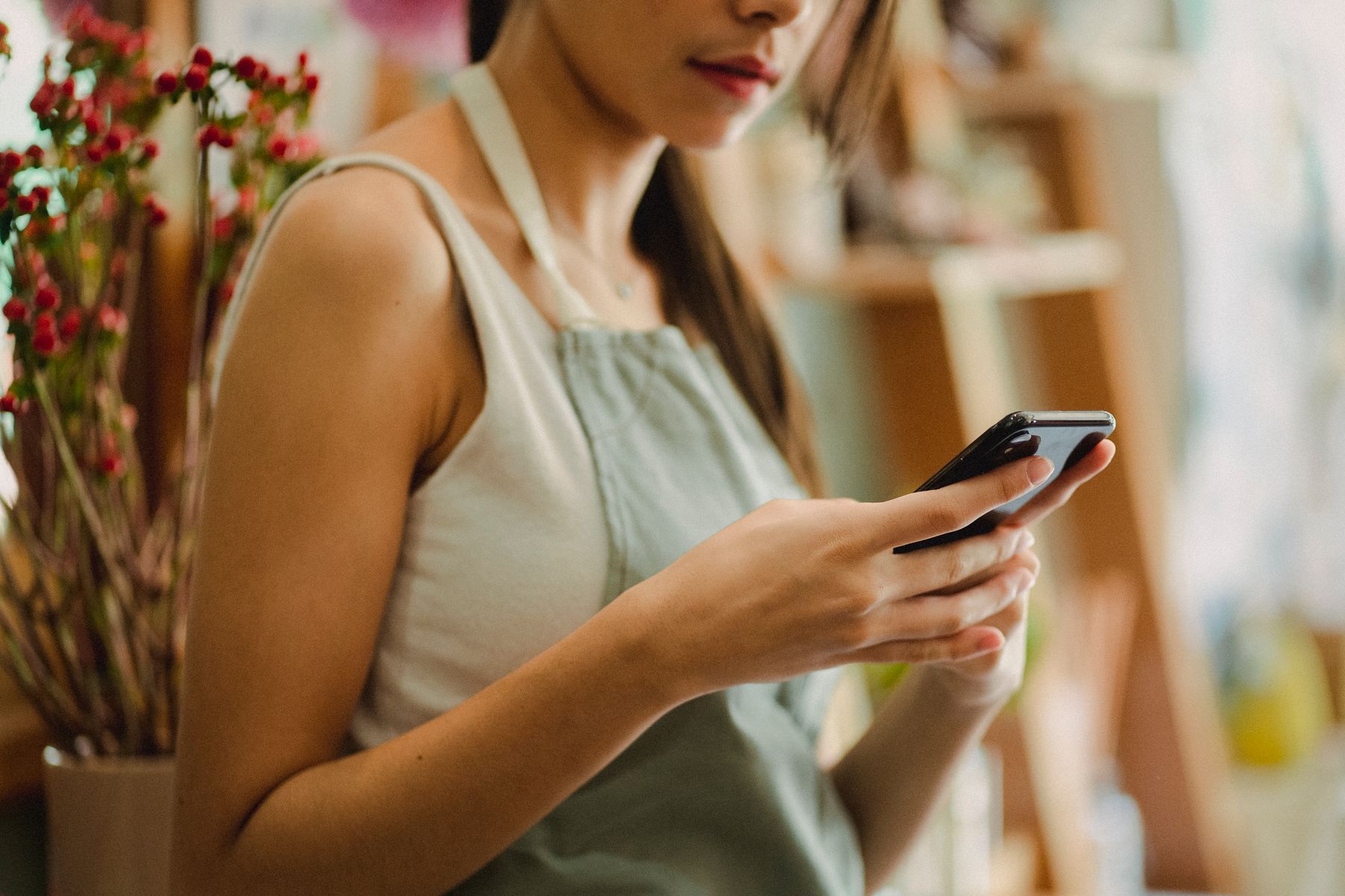 Shop owner checking her phone at the counter