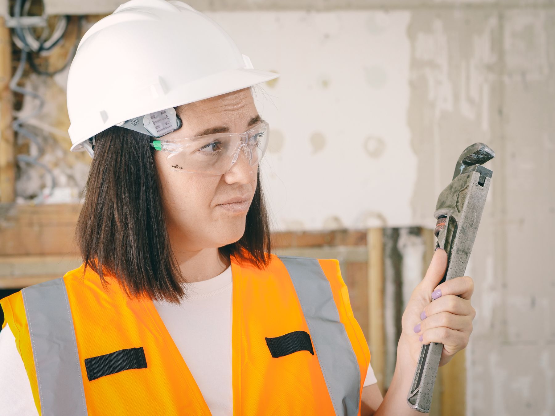 Plumber holding a pipe wrench on a job